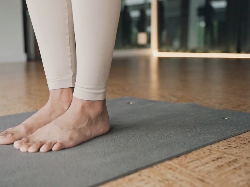 devojka stoji na prostirci za trening